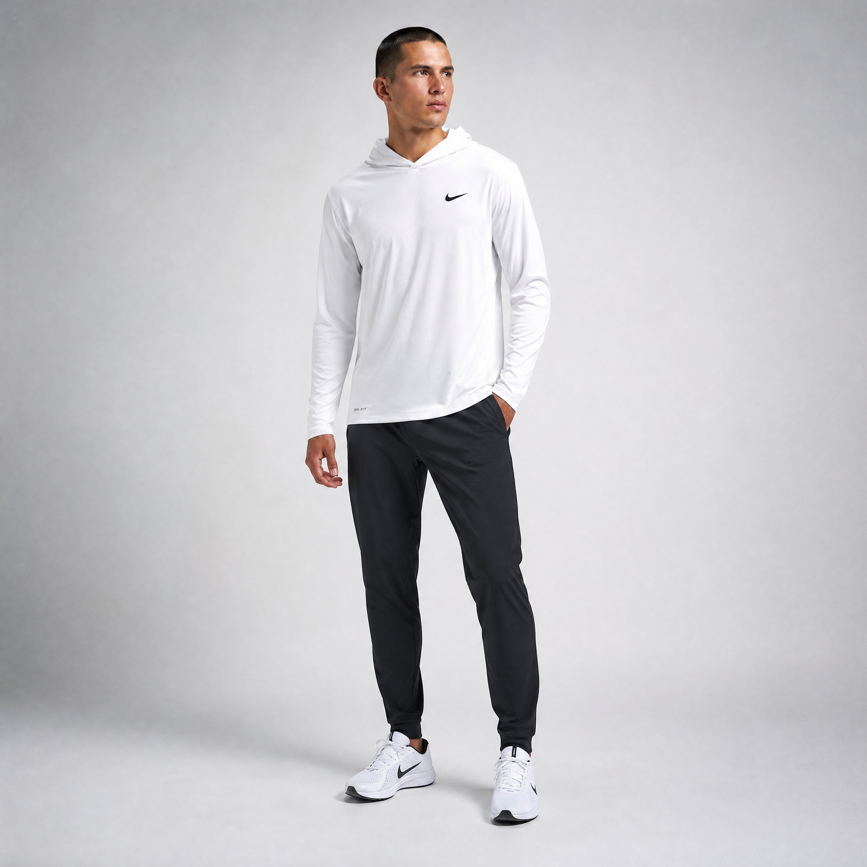 Male athlete modeling the white Nike Dri-FIT Long Sleeve Hoodie Tee