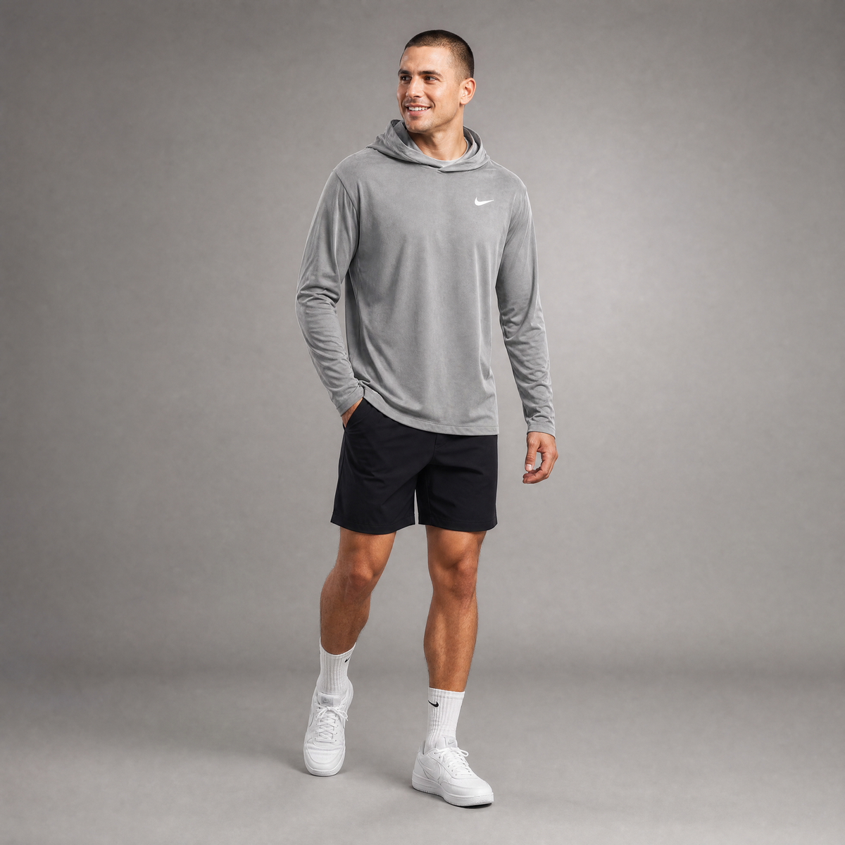 Male athlete modeling the gray Nike Dri-FIT Long Sleeve Hoodie Tee