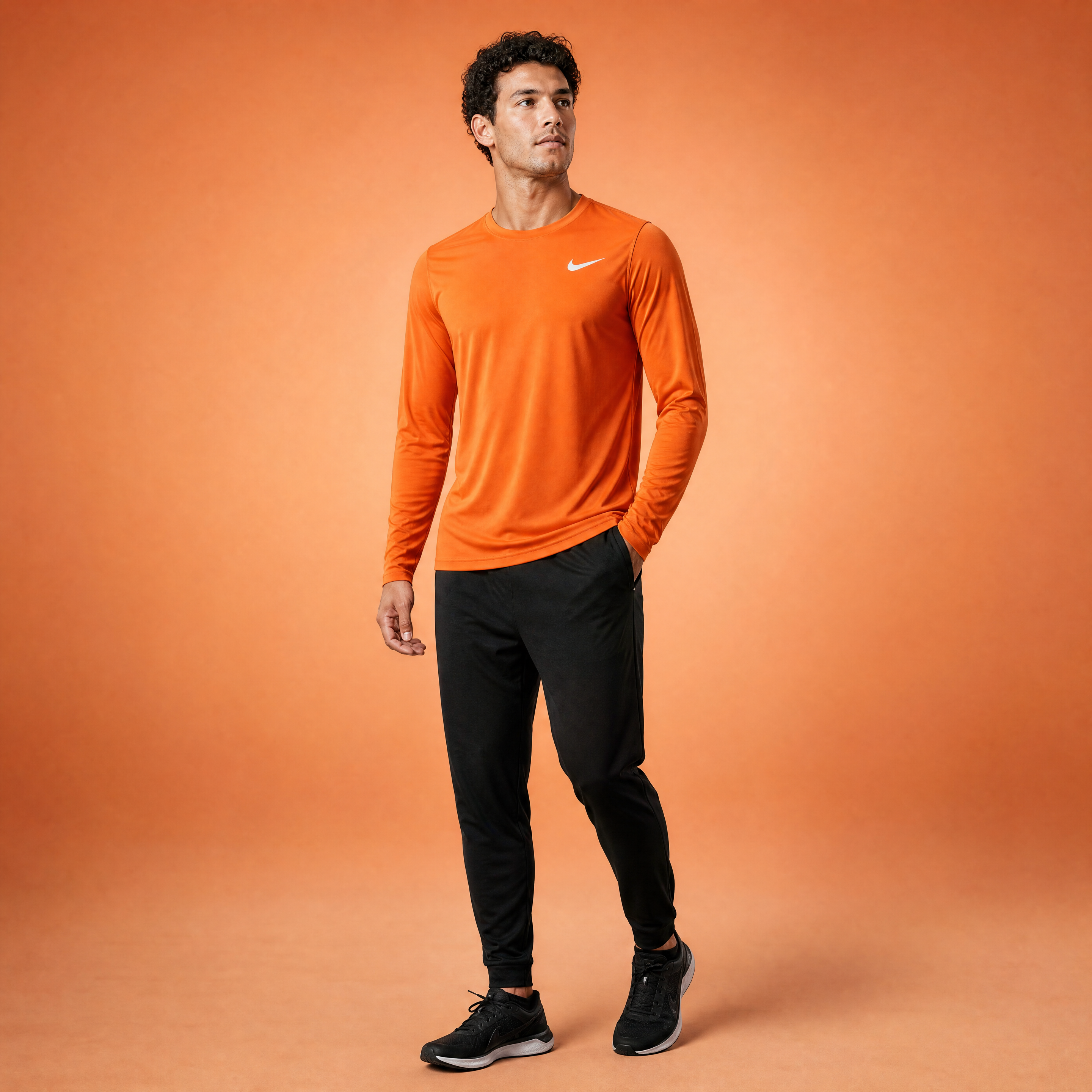 Male athlete modeling the orange Nike Long Sleeve Dri-FIT Athletic Shirt